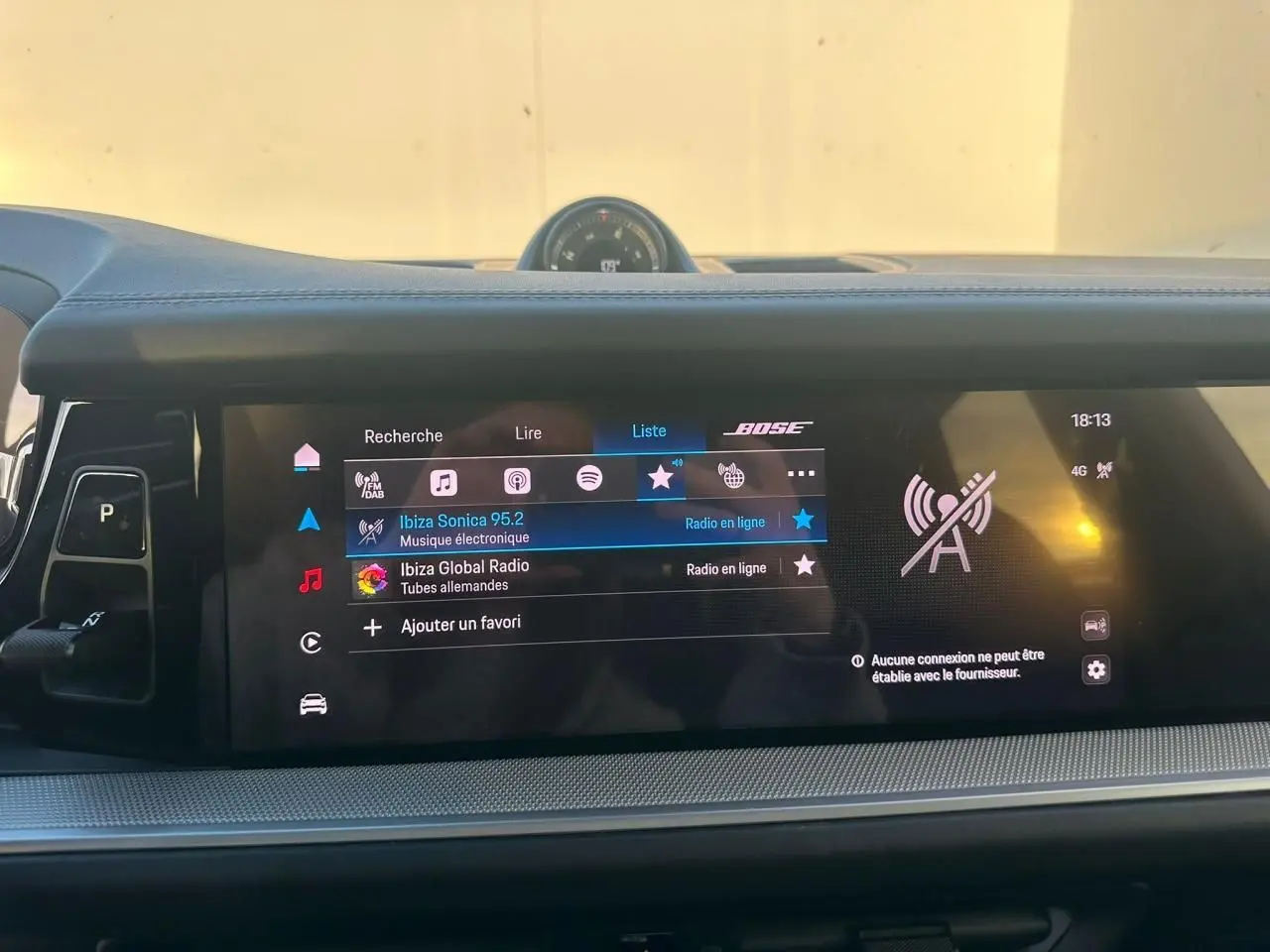 Vue intérieure du tableau de bord du Porsche Cayenne III Coupe 3.0 V6 S E-Hybrid 2024, écran tactile avec interface audio et horloge centrale.