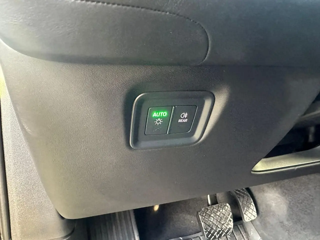 Détail des commandes d’éclairage avec bouton auto allumé sur Porsche Cayenne 2024, intérieur côté conducteur.