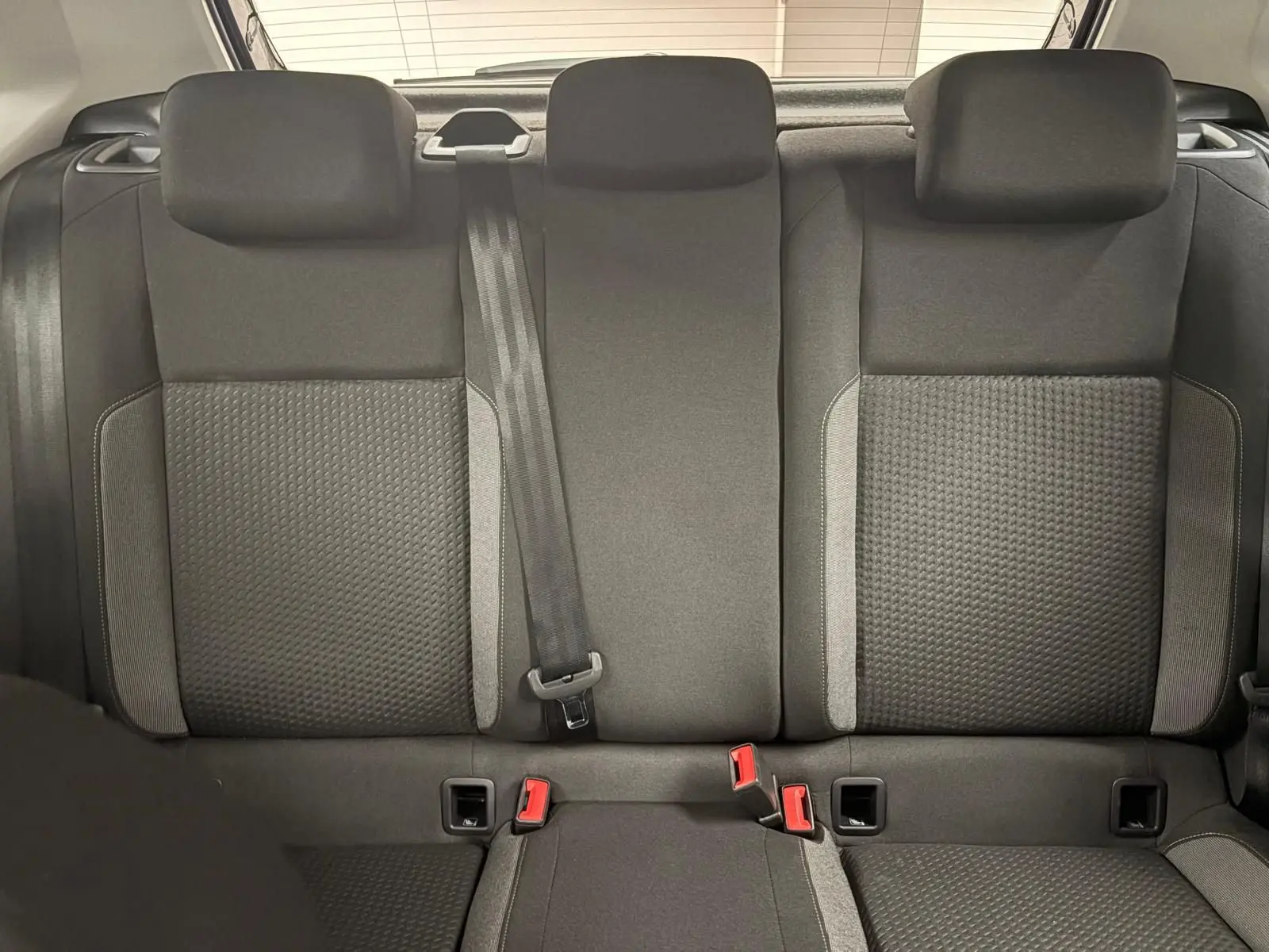 Banquette arrière noire de Volkswagen Polo 2025 vue de face avec ceintures et appuis-tête visibles.