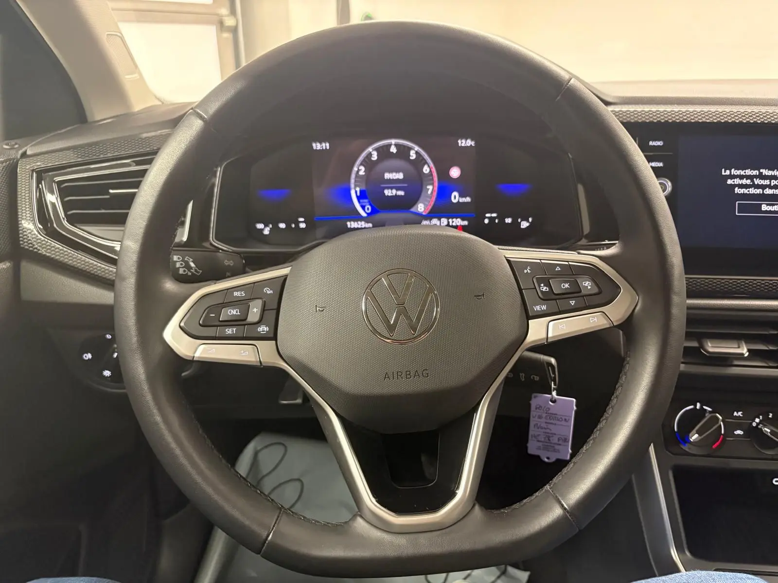 Vue rapprochée du volant cuir multifonctions noir de la Volkswagen Polo 2025 avec tableau de bord digital et écran tactile.