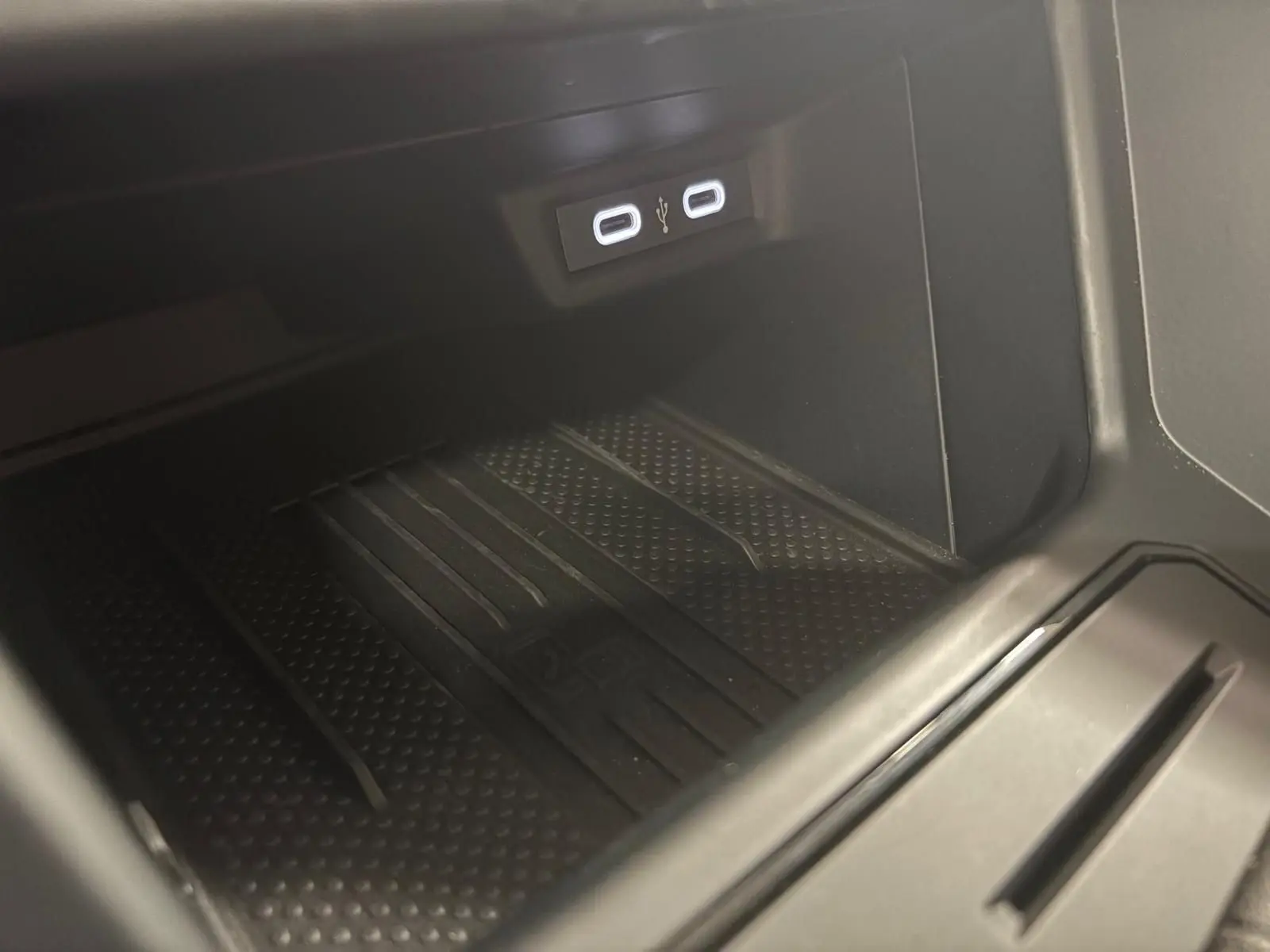 Gros plan sur la console centrale intérieure de la Volkswagen Polo noire, montrant deux ports USB-C éclairés.