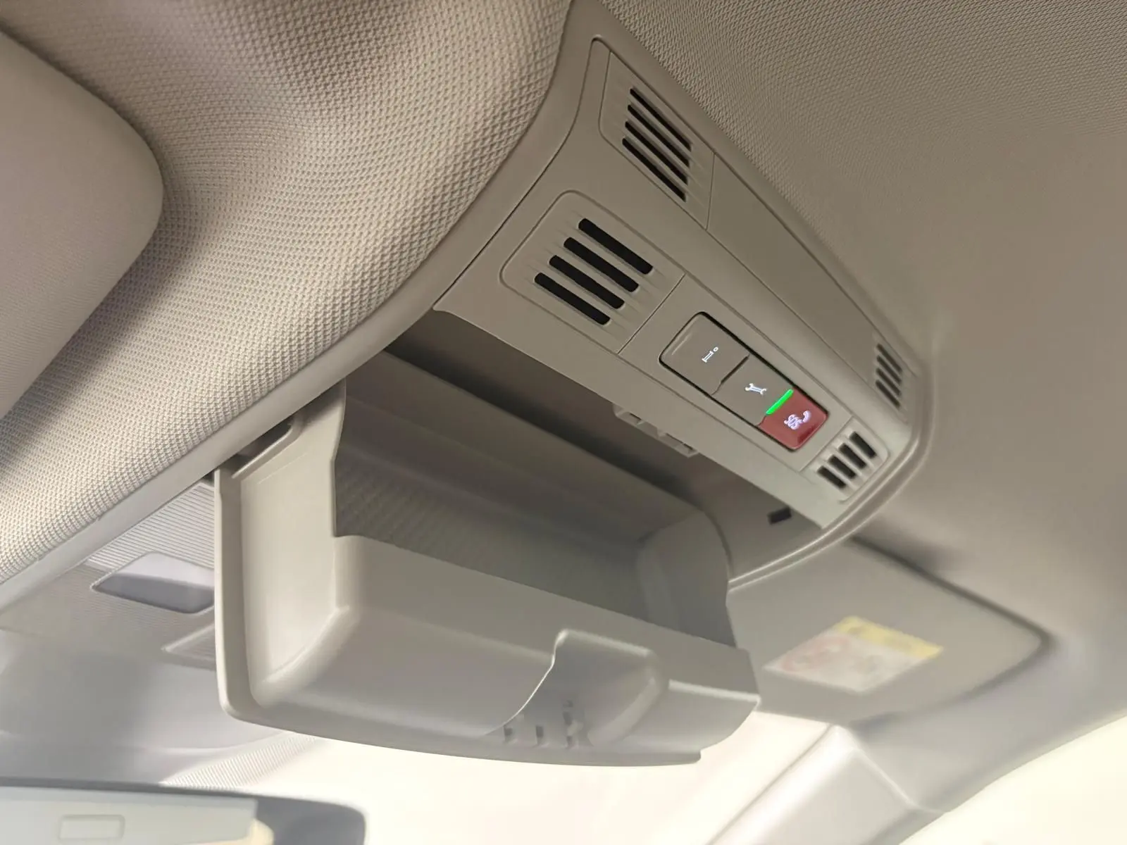 Détail du plafond intérieur beige de la Volkswagen Polo 2025 avec rangement lunettes et boutons d'appel d'urgence.