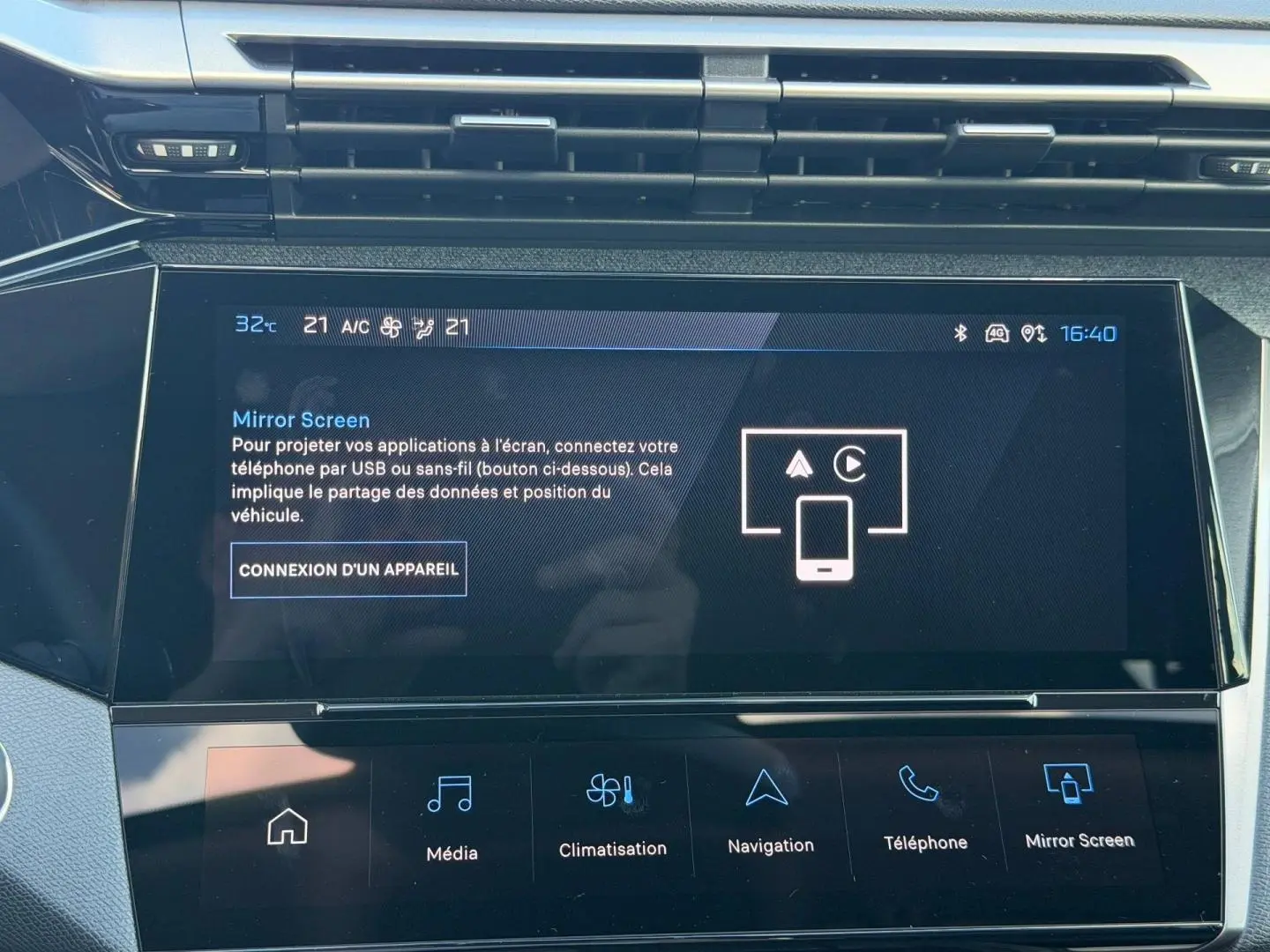 Gros plan sur l'écran tactile central de la Peugeot 308 rouge Elixir, affichant le menu Mirror Screen.