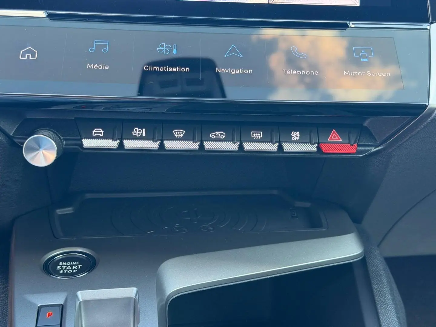 Vue rapprochée de la console centrale de la Peugeot 308 rouge, montrant les commandes tactiles et le bouton start/stop.
