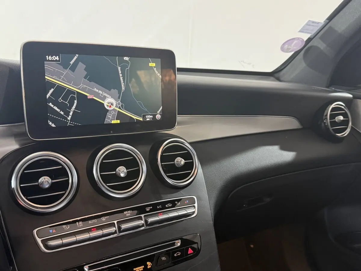 Vue intérieure du tableau de bord du Mercedes GLC 250 Fascination 2019 avec écran de navigation et aérateurs ronds chromés.