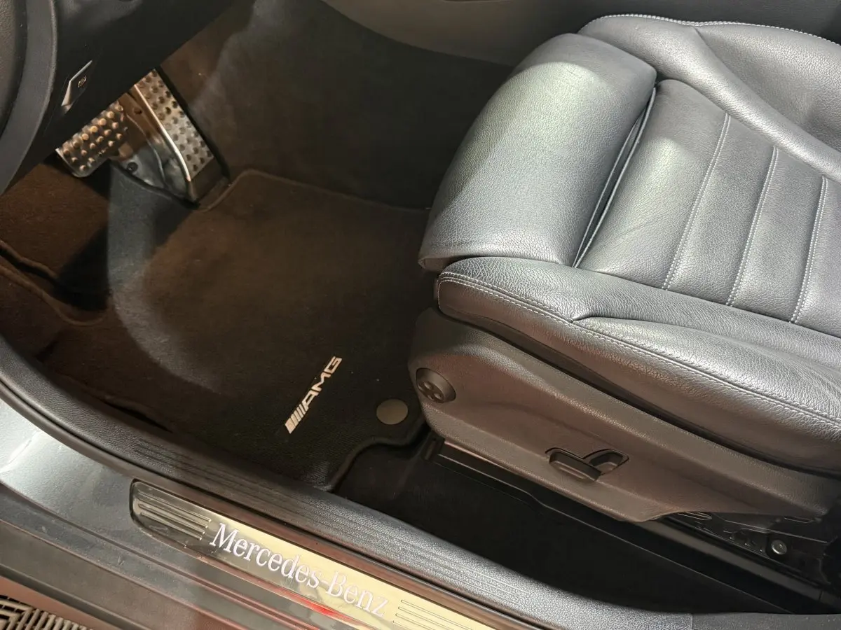 Vue intérieure côté conducteur du Mercedes GLC 250 Fascination 4Matic 2019, siège cuir noir et tapis AMG.