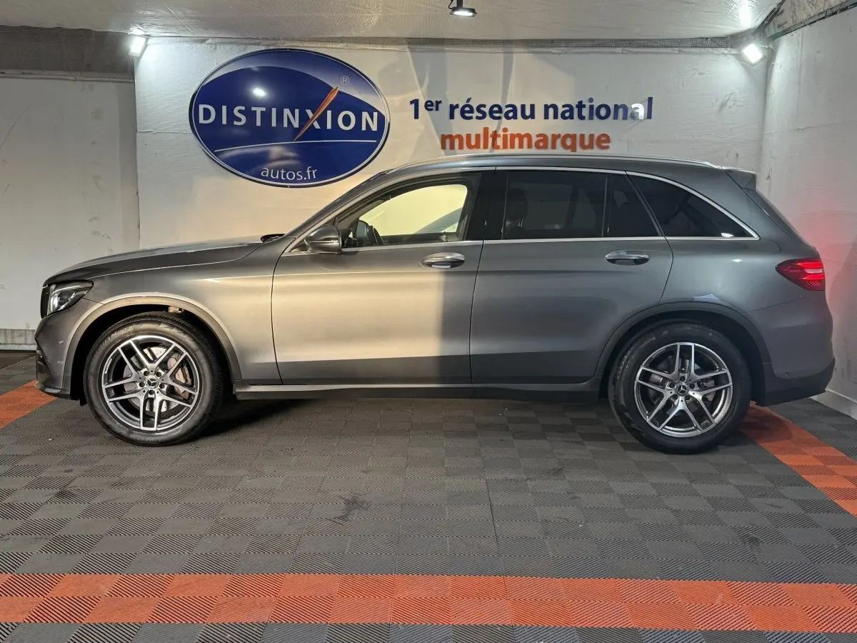 Mercedes GLC 250 Fascination 4Matic gris foncé, vue de profil côté gauche en intérieur avec jantes alliage visibles.