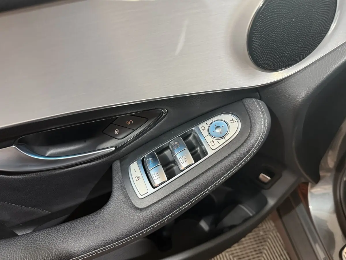 Gros plan sur la commande des vitres et rétroviseurs côté conducteur d’une Mercedes GLC 250 Fascination gris foncé.