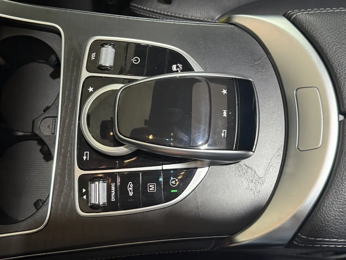 Gros plan sur la console centrale noire et argentée du Mercedes GLC 250 Fascination 2019 avec commandes tactiles et molette.