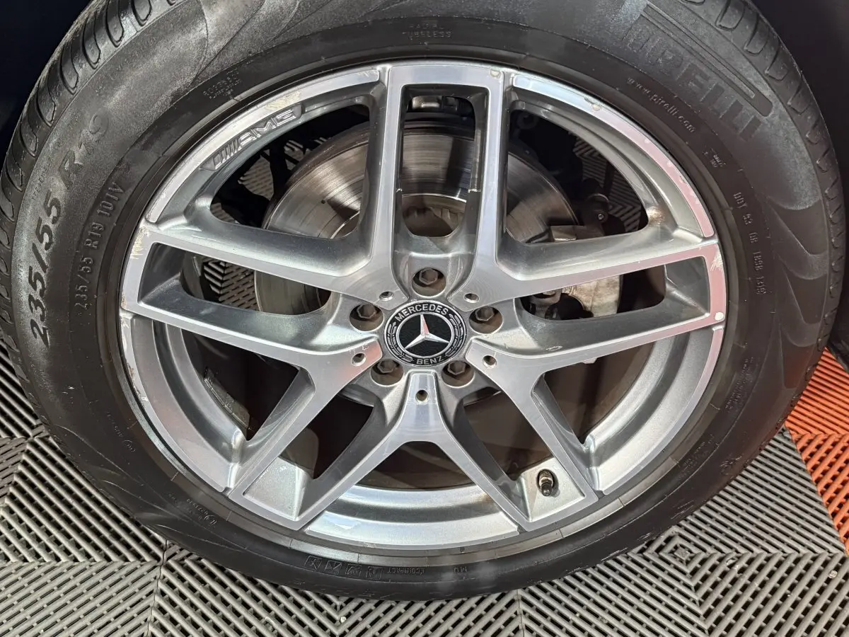 Gros plan sur la jante AMG argentée et le pneu Pirelli d’un Mercedes GLC 250 Fascination 2019 gris foncé.