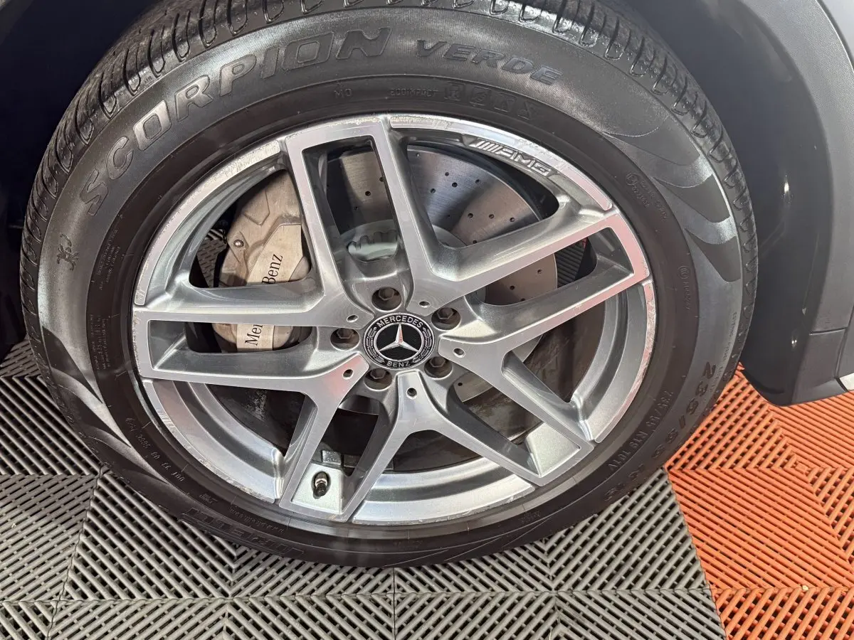Gros plan sur la jante AMG argentée et le pneu Pirelli Scorpion Verde du Mercedes GLC 250 Fascination gris foncé.