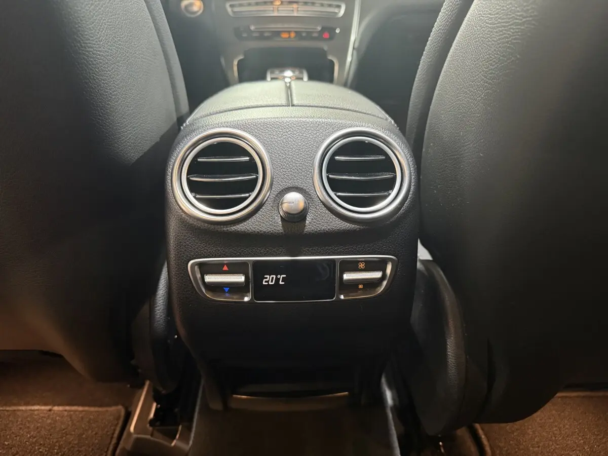 Vue rapprochée de la console centrale arrière noire du Mercedes GLC 250 Fascination 2019 avec réglage climatisation à 20°C.