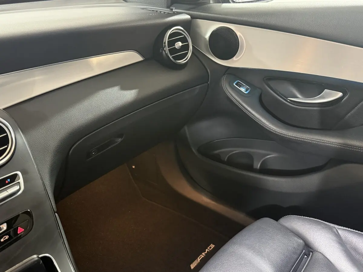 Vue intérieure côté passager du Mercedes GLC 250 Fascination 2019, avec garnitures noires et inserts aluminium, tapis AMG visible.