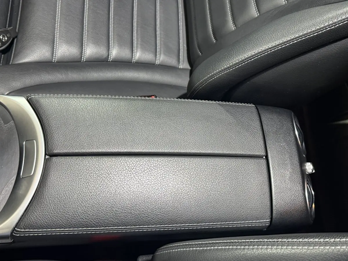 Gros plan sur l'accoudoir central en cuir noir avec surpiqûres blanches de la Mercedes GLC 250 Fascination 2019.