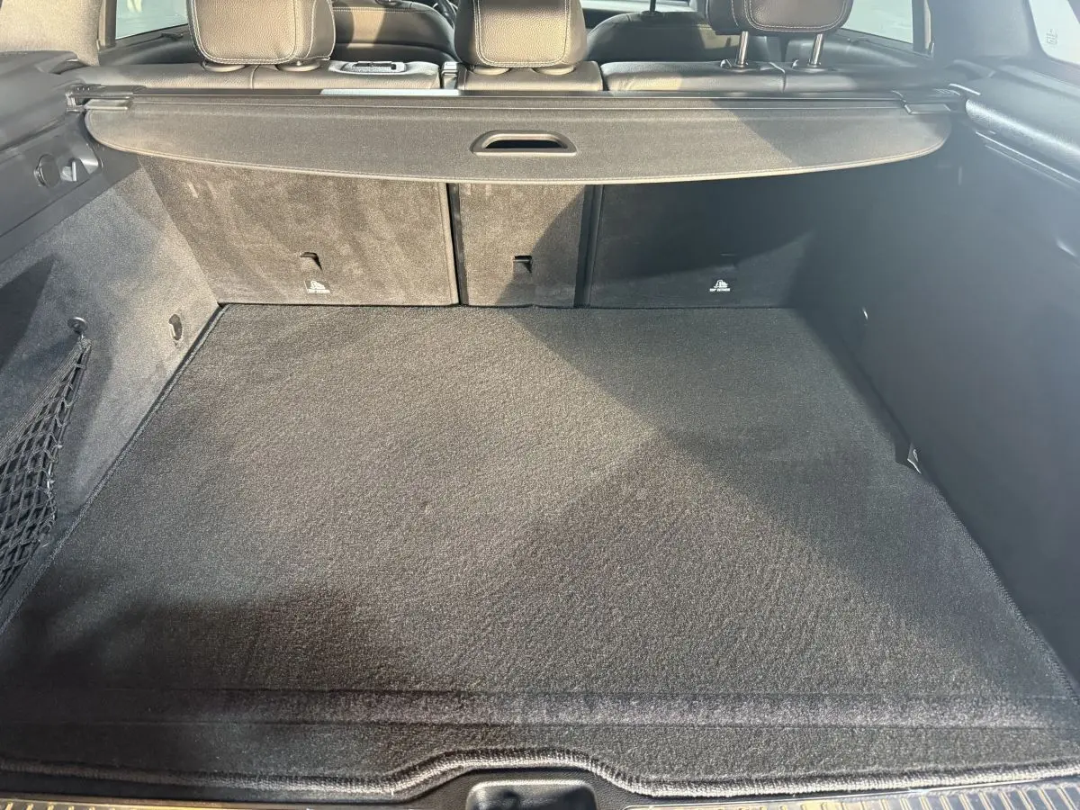 Coffre spacieux vu de l’arrière d’un Mercedes GLC 250 Fascination 4Matic gris foncé, avec cache-bagages déployé.