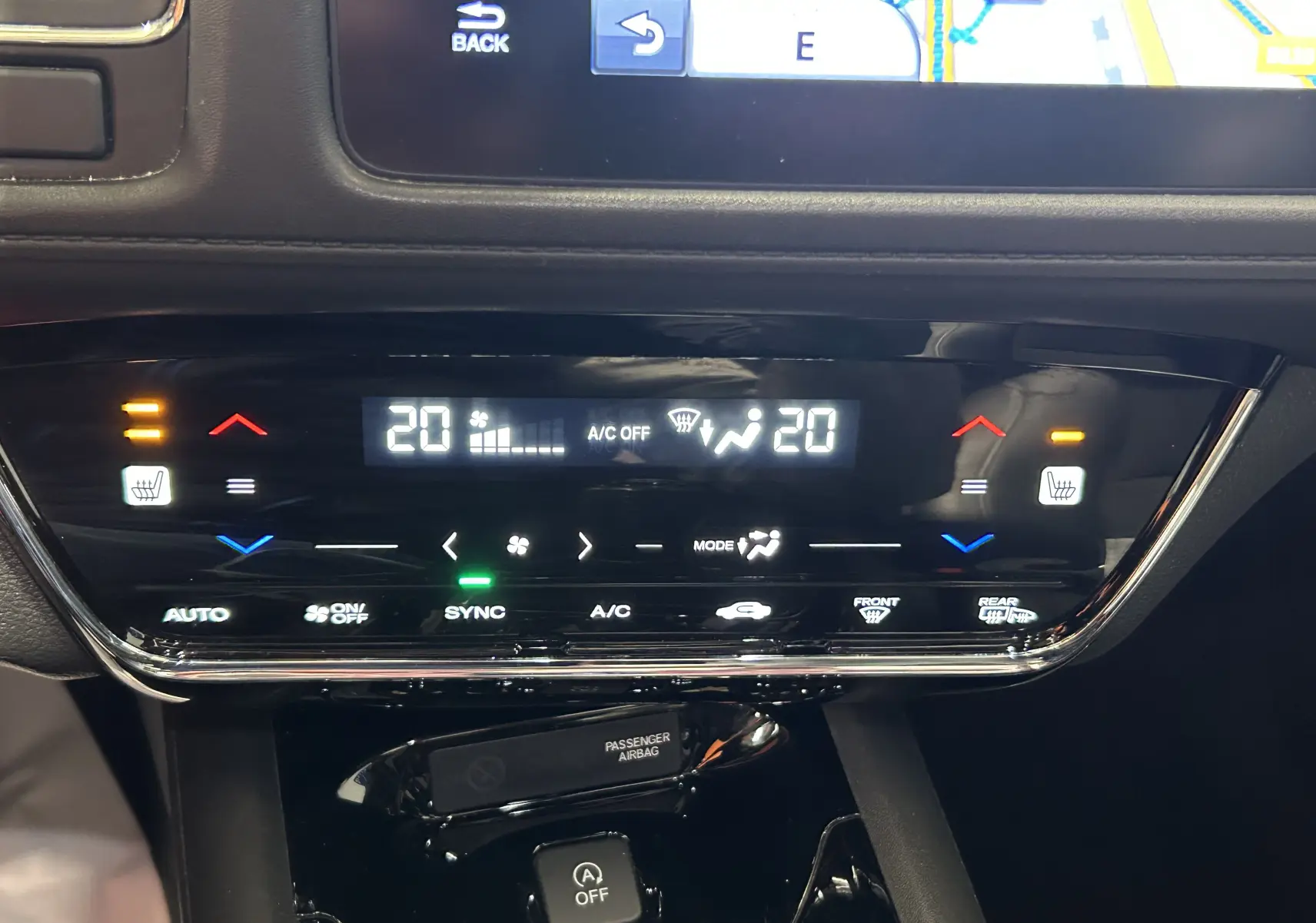 Détail du tableau de bord du Honda HR-V 2020 bleu, montrant la climatisation digitale avec réglages à 20°C et sièges chauffants activés.