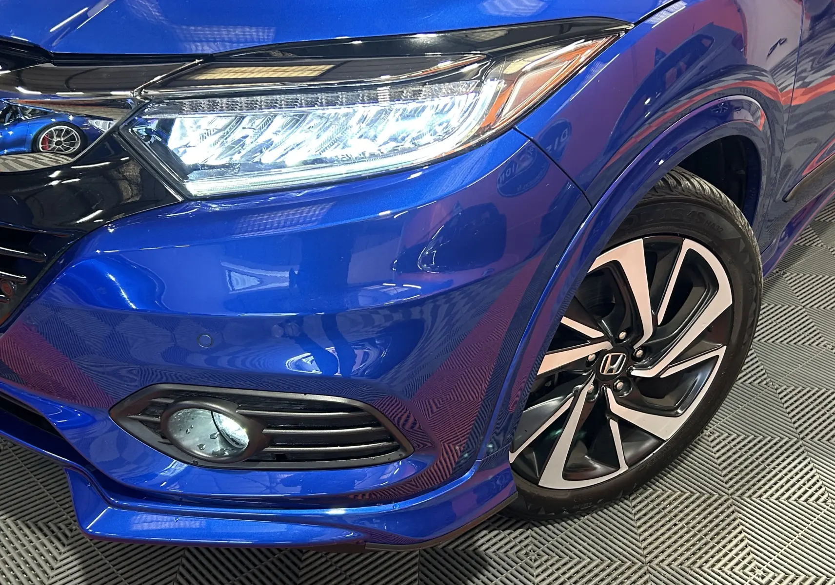 Gros plan sur l'avant droit bleu vif du Honda HR-V 2020, mettant en valeur le phare LED et la jante alliage bicolore.