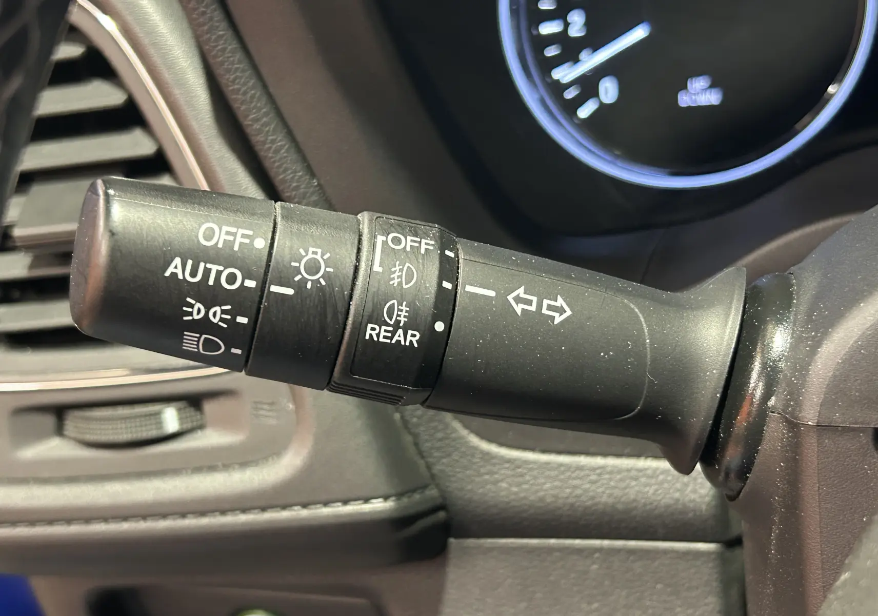 Gros plan sur la commande des feux et clignotants du Honda HR-V 2020, intérieur noir avec détails blancs.