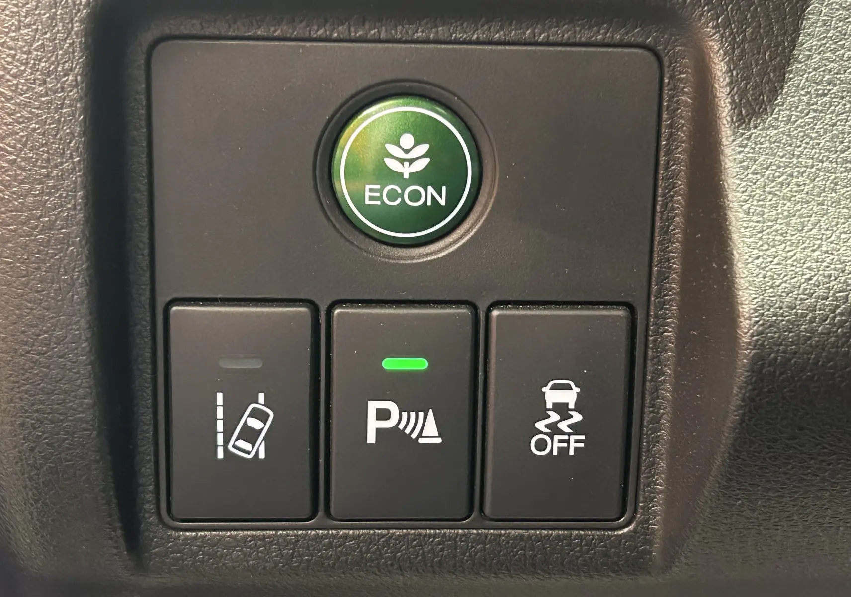 Gros plan sur les boutons de commande du tableau de bord du Honda HR-V 2020, avec bouton ECON vert et indicateurs d'aide à la conduite.