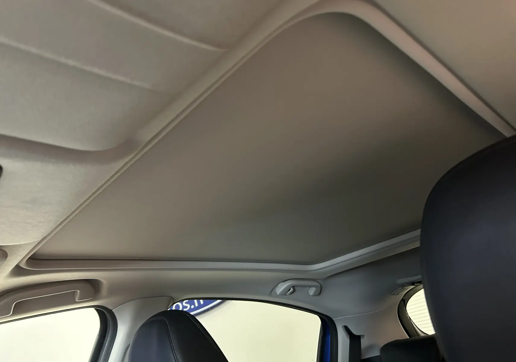 Vue intérieure du toit ouvrant fermé du Honda HR-V bleu, avec sièges avant en cuir noir visibles de côté droit.