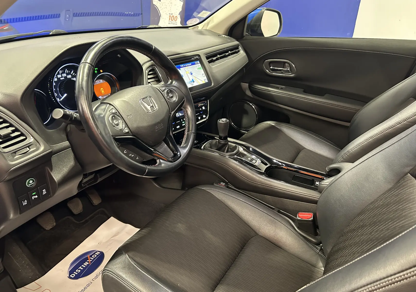 Vue intérieure côté conducteur du Honda HR-V 2020 avec volant cuir, tableau de bord noir et écran tactile GPS.