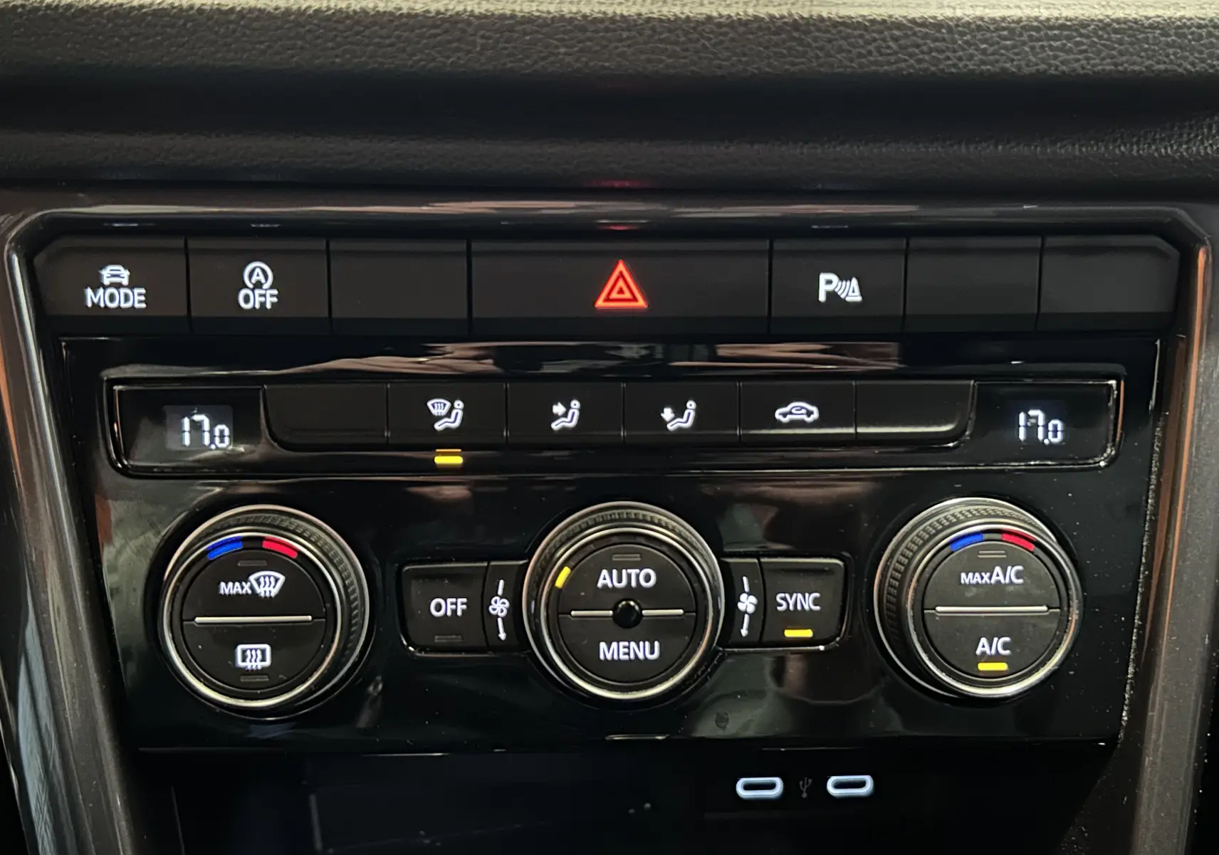Tableau de bord noir du Volkswagen T-Roc 2020, vue rapprochée sur la console de climatisation digitale et boutons.