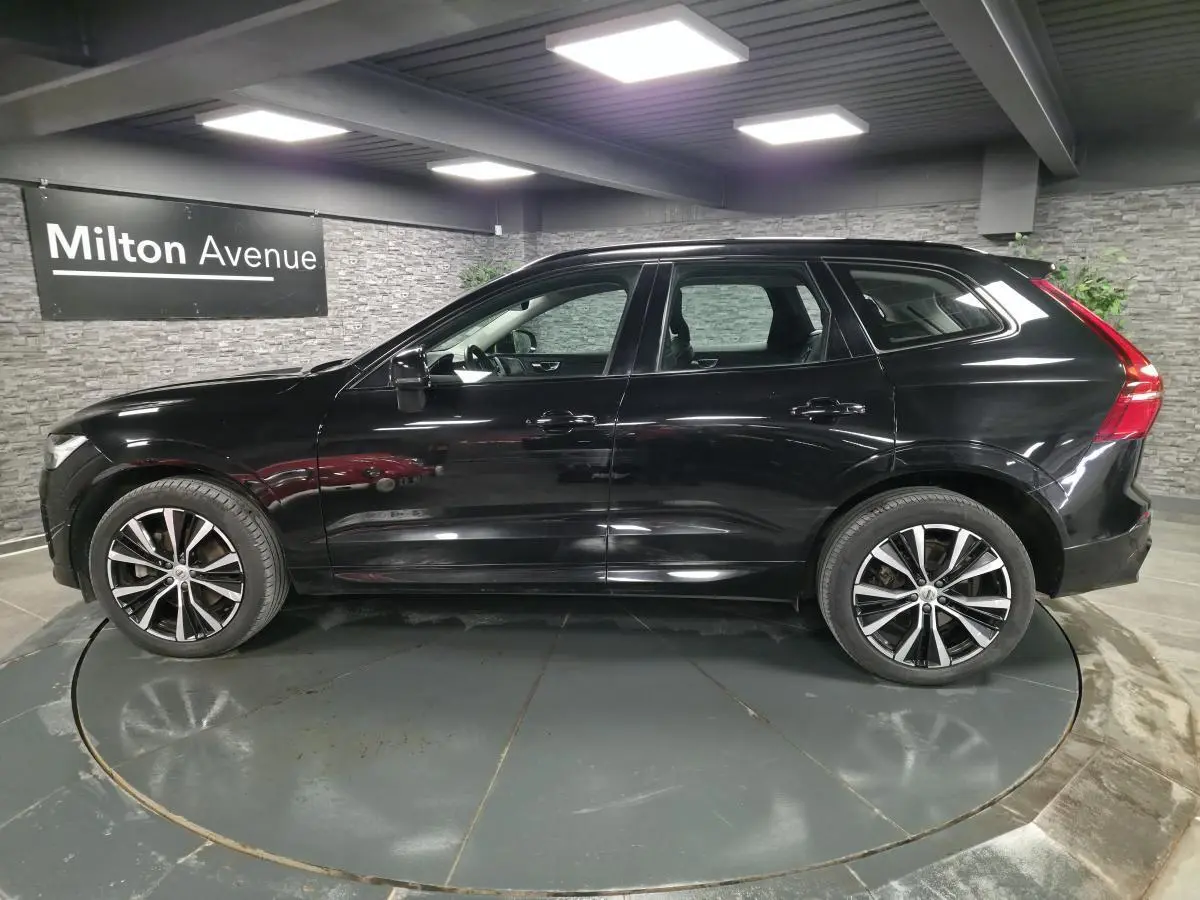 Vue de profil côté gauche d'un Volvo XC60 noir métallisé avec jantes alliage 20 pouces en Y noir et diamant.