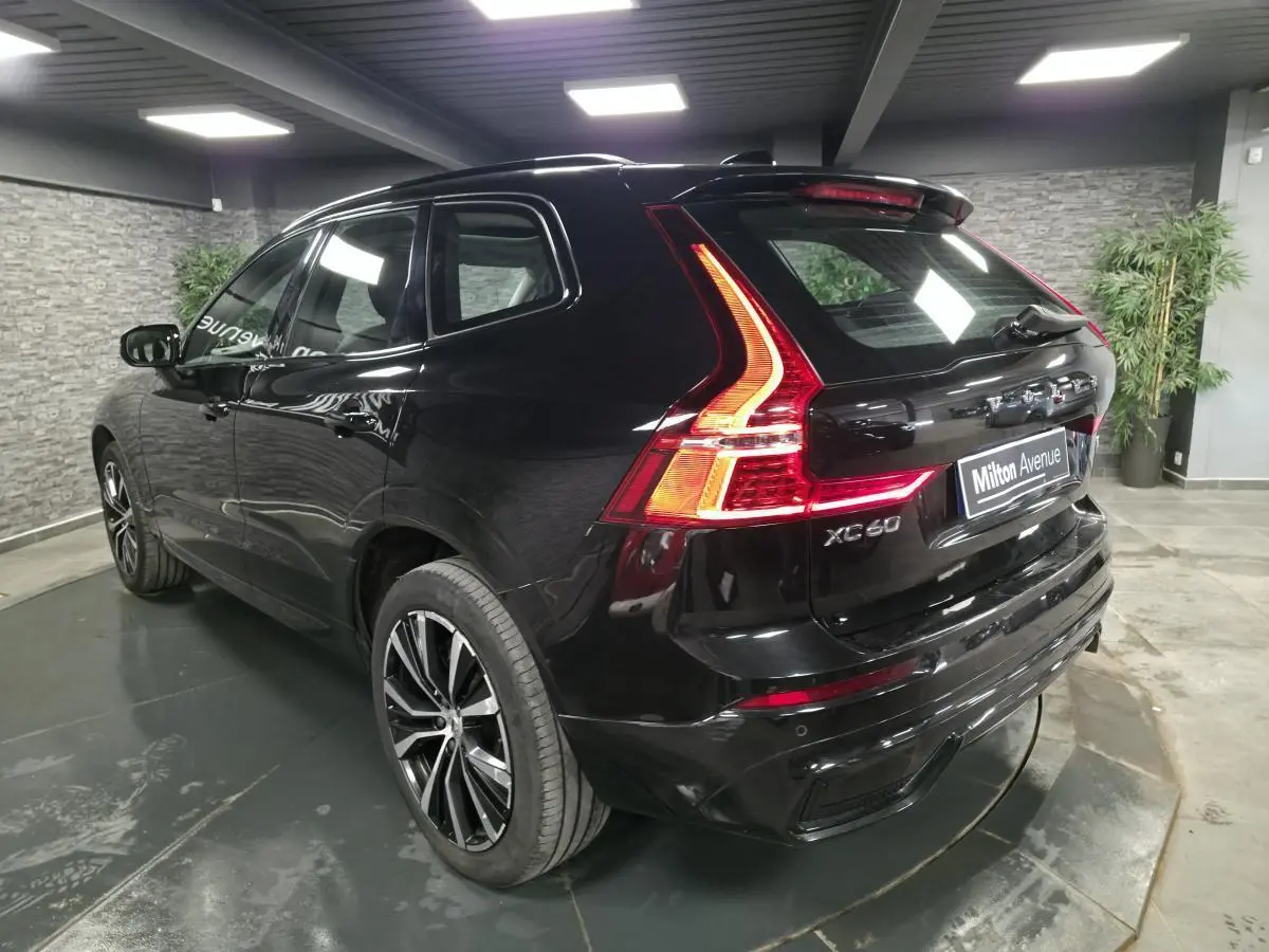 Vue 3/4 arrière droite du Volvo XC60 noir avec feux arrière LED et jantes alliage 20 pouces en Y.