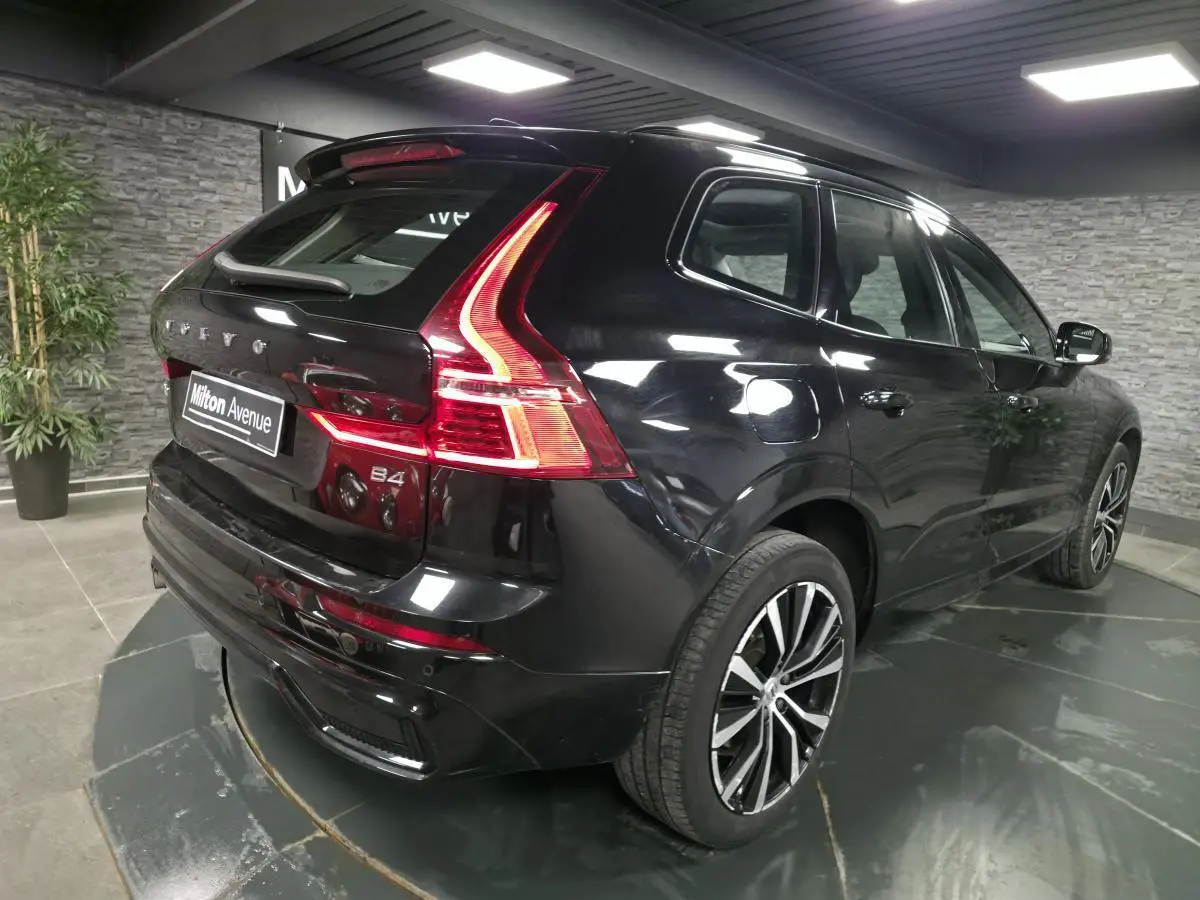 Vue 3/4 arrière droite du Volvo XC60 B4 micro-hybride diesel noir métallisé avec jantes alliage 20 pouces et feux LED distinctifs.