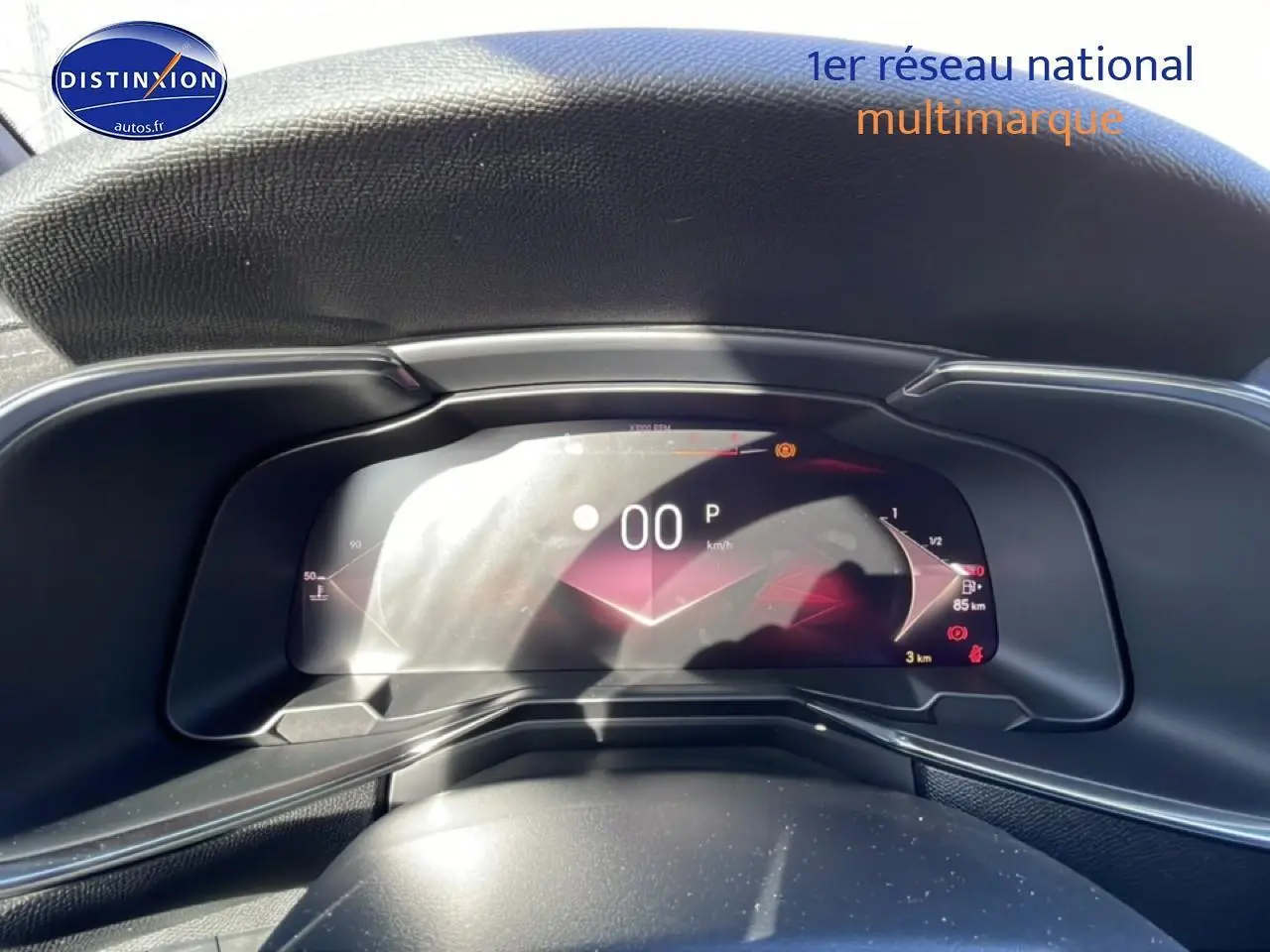 Vue rapprochée du tableau de bord numérique du DS7 bleu, affichant la vitesse à 0 km/h et indicateurs lumineux.