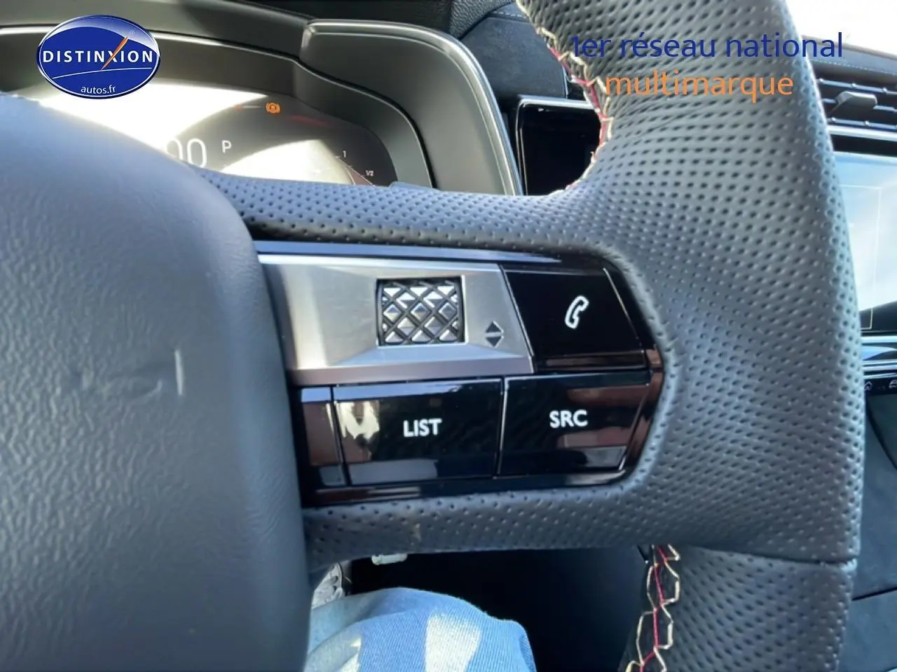 Gros plan sur le volant en cuir perforé noir du DS7 1.5 BlueHDi, avec commandes vocales et téléphone intégrées.