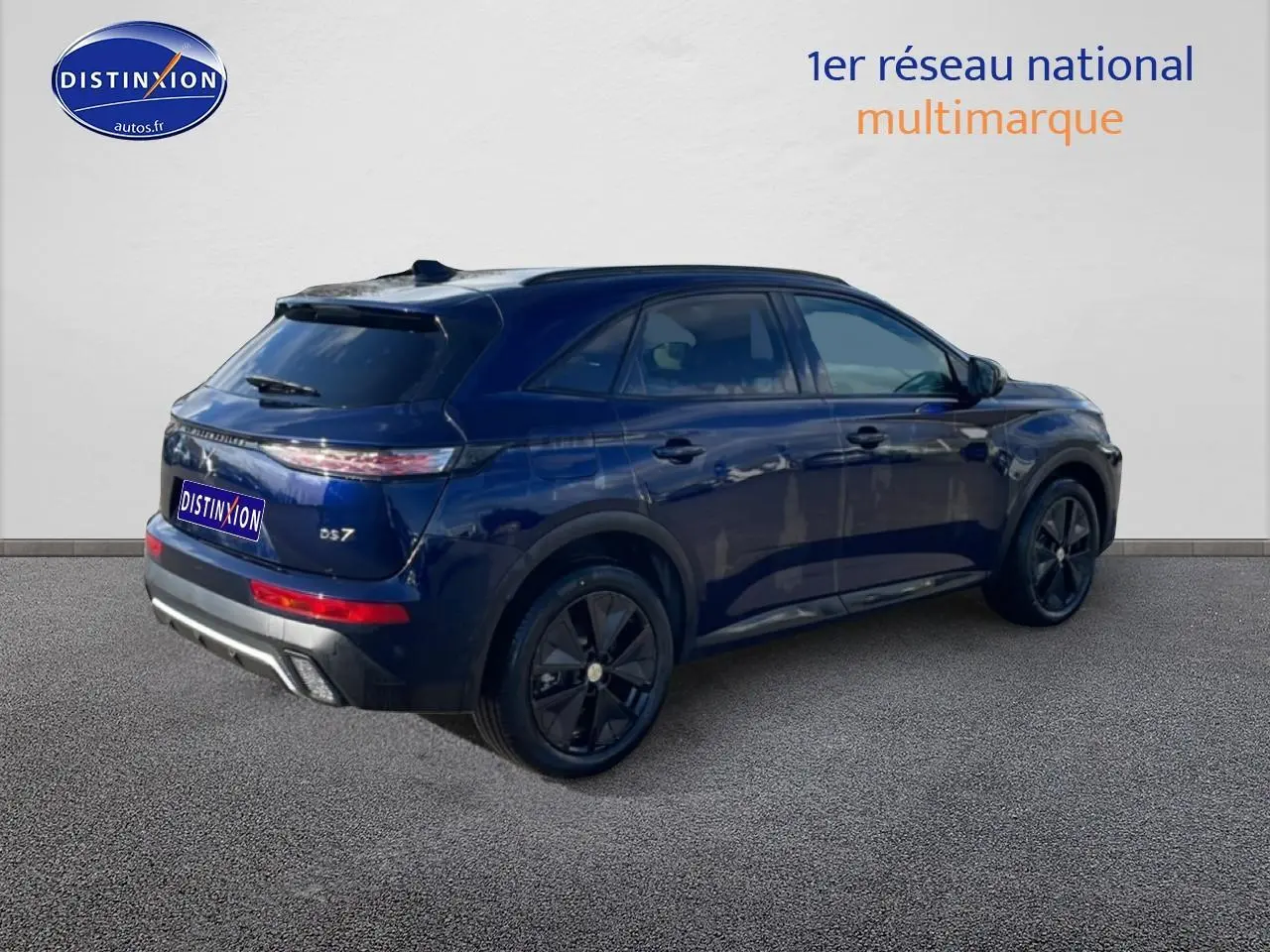 Vue 3/4 arrière droite d'un DS7 bleu foncé avec jantes noires et vitres arrière surteintées.