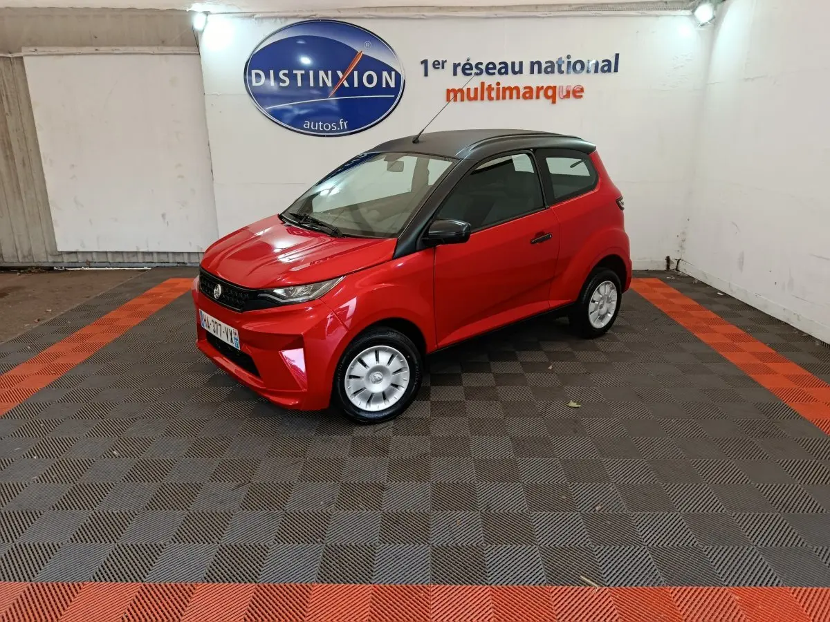 Vue 3/4 avant droite d'une Aixam Ambition 0.5 City Crossline Pack rouge avec toit noir et rétroviseur côté conducteur.