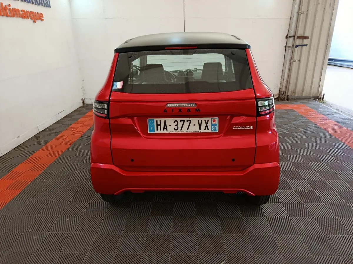 Vue arrière d'une Aixam Ambition 0.5 City Crossline Pack rouge 2024 avec plaque d'immatriculation française.