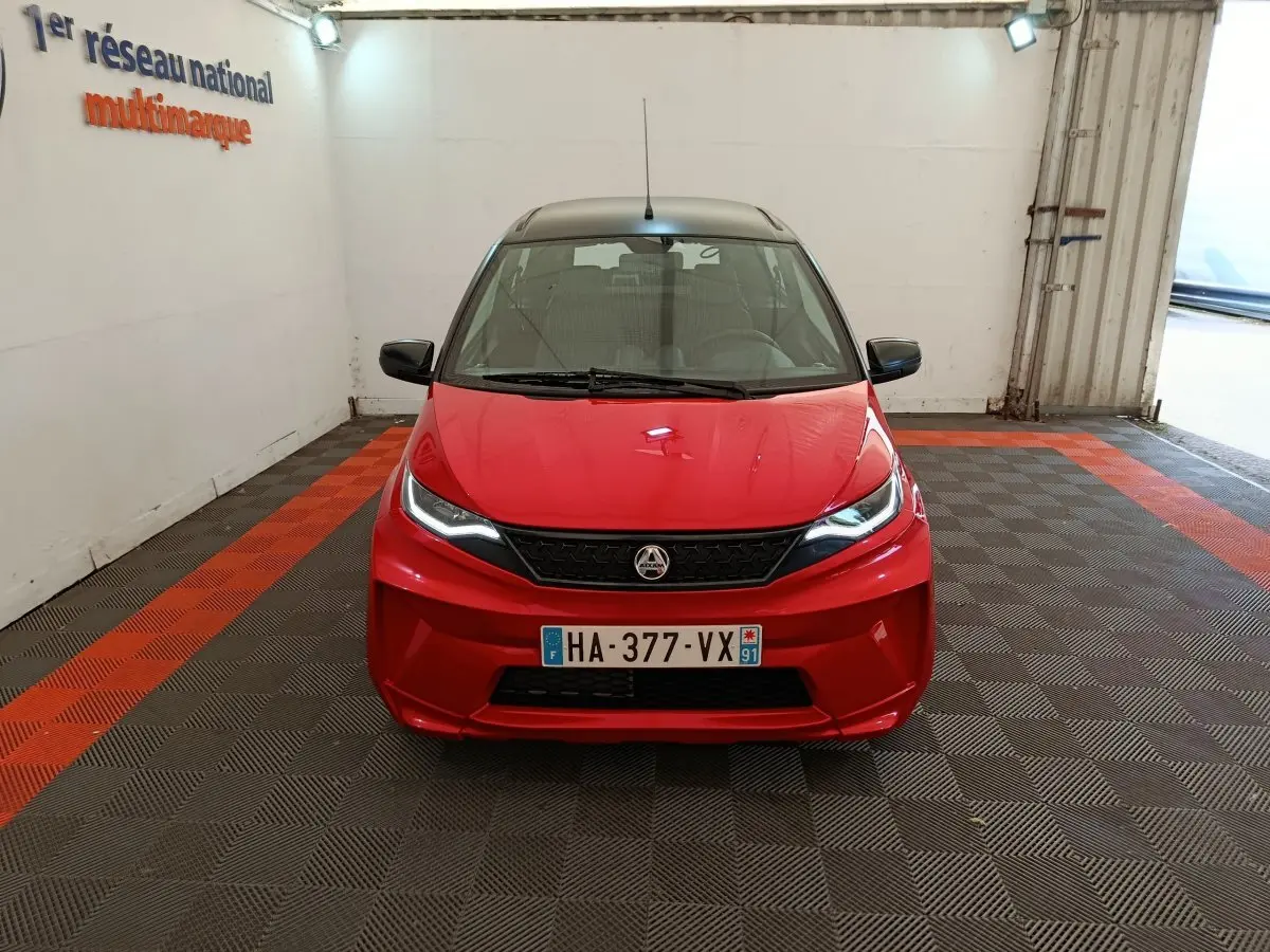 Vue frontale d'une Aixam Ambition 0.5 City Crossline Pack rouge 2024 avec rétroviseurs noirs et plaque française.