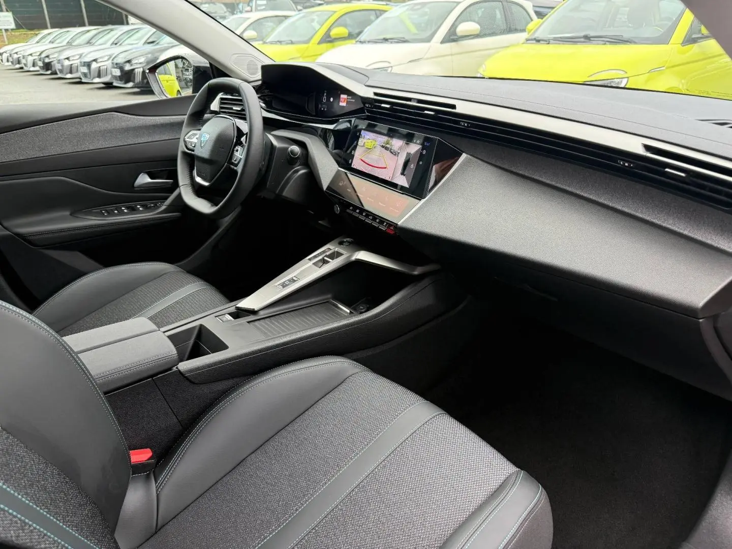 Vue intérieure côté conducteur de la Peugeot 308 SW 2025 avec tableau de bord moderne et écran tactile.