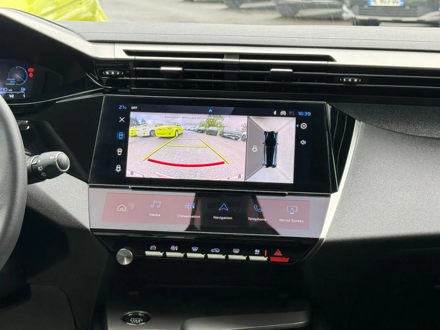 Vue intérieure du tableau de bord de la Peugeot 308 SW 2025 avec écran tactile affichant la caméra de recul et les commandes multimédia.