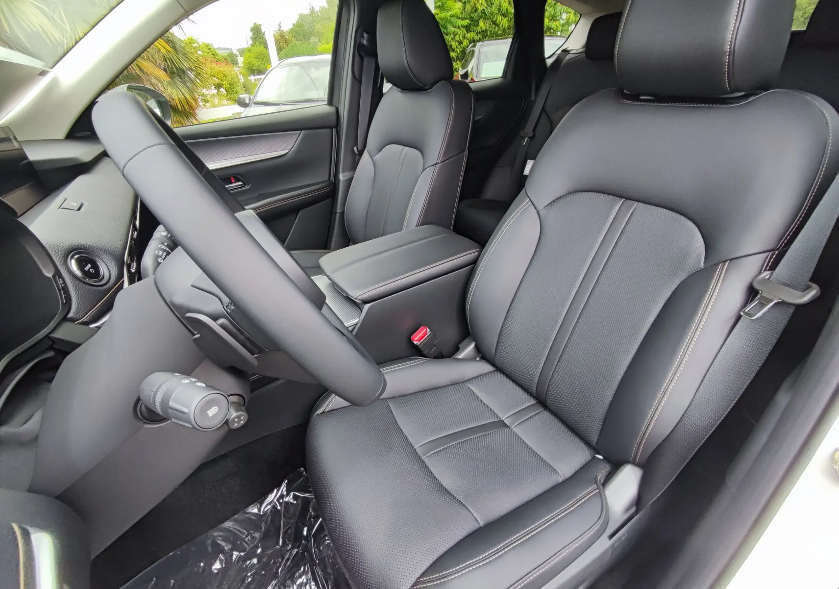 Vue intérieure côté conducteur du Mazda CX-60 2024, sièges en cuir noir avec surpiqûres contrastées et volant visible.