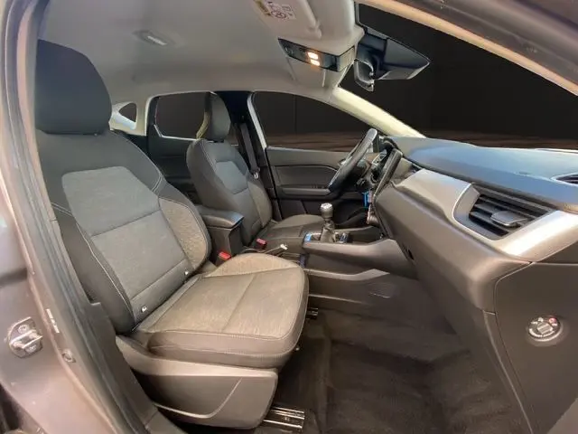 Intérieur avant du Renault Captur TCE 90 Équilibre 2023, sièges gris noir et tableau de bord moderne côté conducteur.