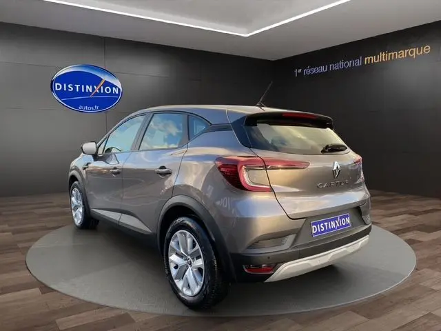 Vue 3/4 arrière droite d'un Renault Captur gris Cassiopée 2023, SUV compact avec feux LED et jantes alliage.