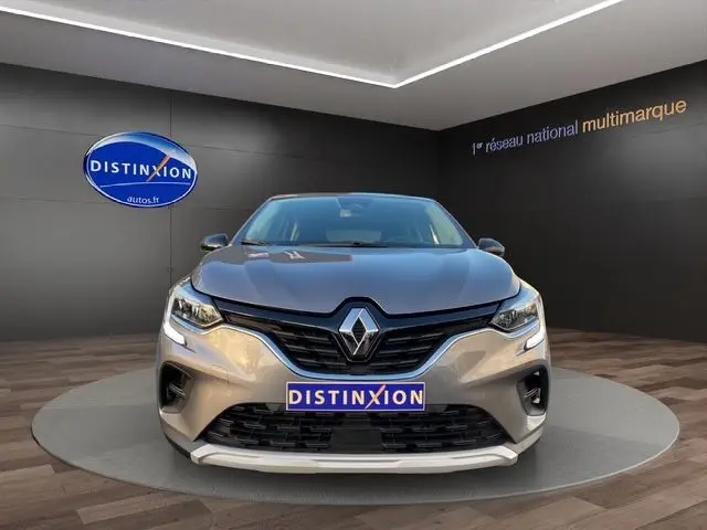 Vue frontale d'un Renault Captur gris Cassiopée 2023 avec calandre noire et logo chromé bien visible.