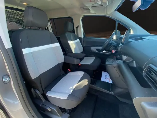 Vue intérieure côté conducteur du Citroën Berlingo gris Artense, montrant les sièges tissu bicolore et le tableau de bord moderne.