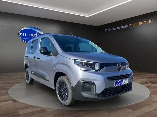 Vue 3/4 avant droit d'un Citroën Berlingo gris Artense avec jantes alliage noires et calandre moderne.