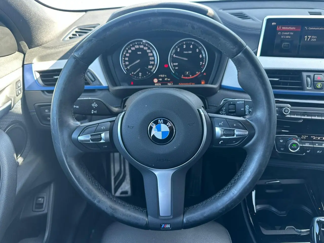 Vue intérieure centrée sur le volant M cuir noir de la BMW X2 2020 avec tableau de bord et écran multimédia visible.