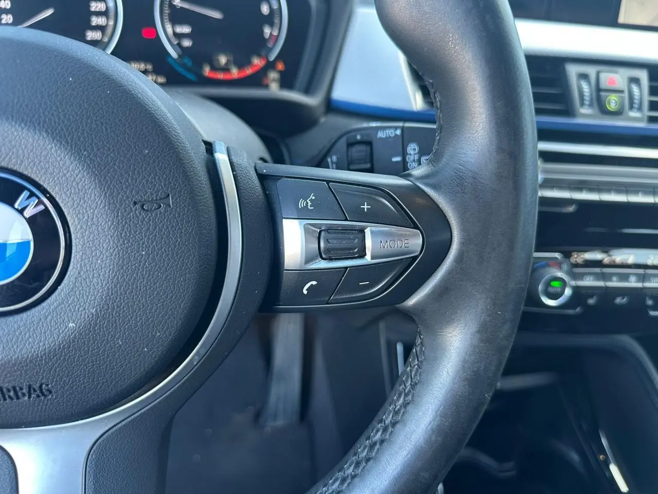 Gros plan sur le volant cuir M de la BMW X2 2020 avec commandes multifonctions et tableau de bord partiel en arrière-plan.