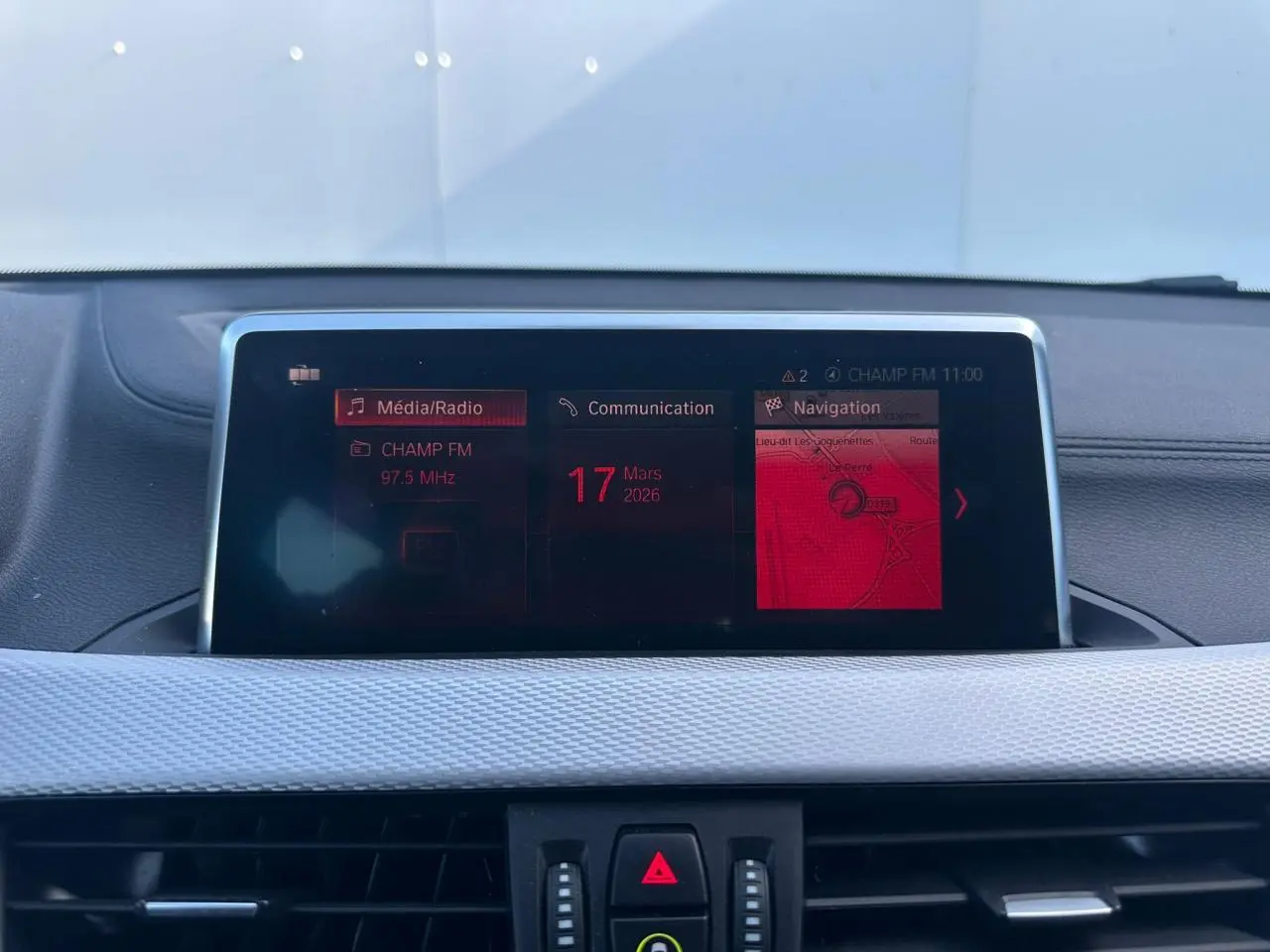 Écran central multimédia de BMW X2 gris foncé (F39) montrant radio, communication et navigation.
