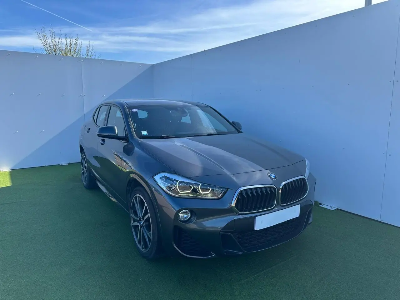 BMW X2 gris foncé vue 3/4 avant droit avec calandre double haricot et jantes alliage 19 pouces style M.