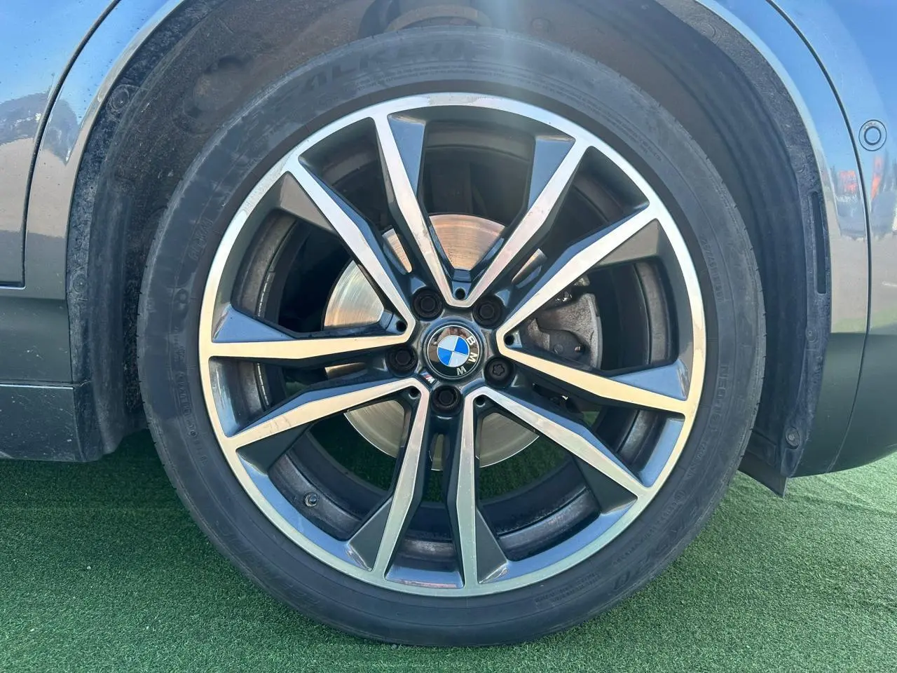 Gros plan sur la jante alliage 19 pouces style 715 M de BMW X2 gris foncé côté gauche.