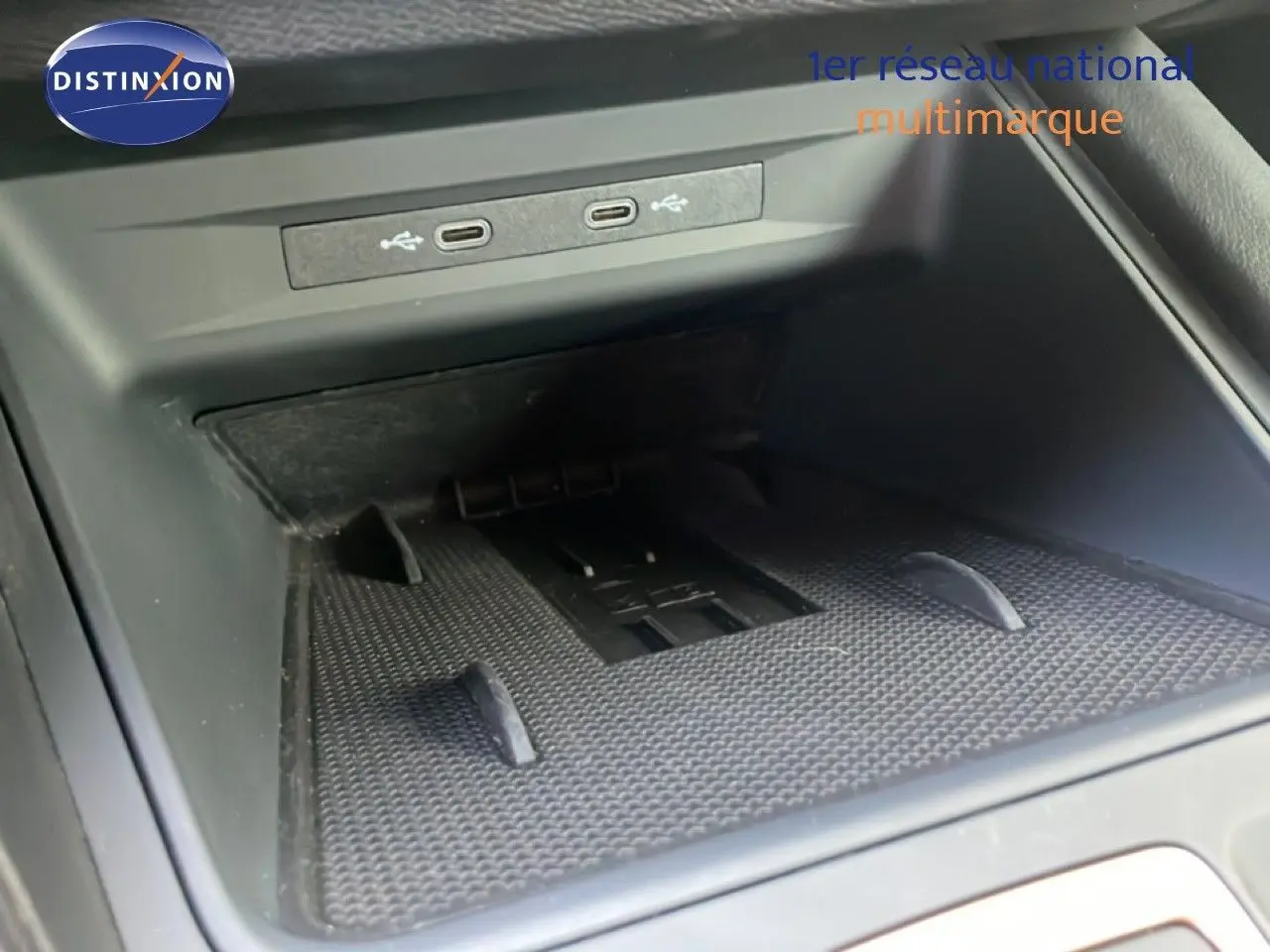 Gros plan sur la console centrale du CUPRA Formentor blanc neige métal, montrant les ports USB et un espace de rangement.