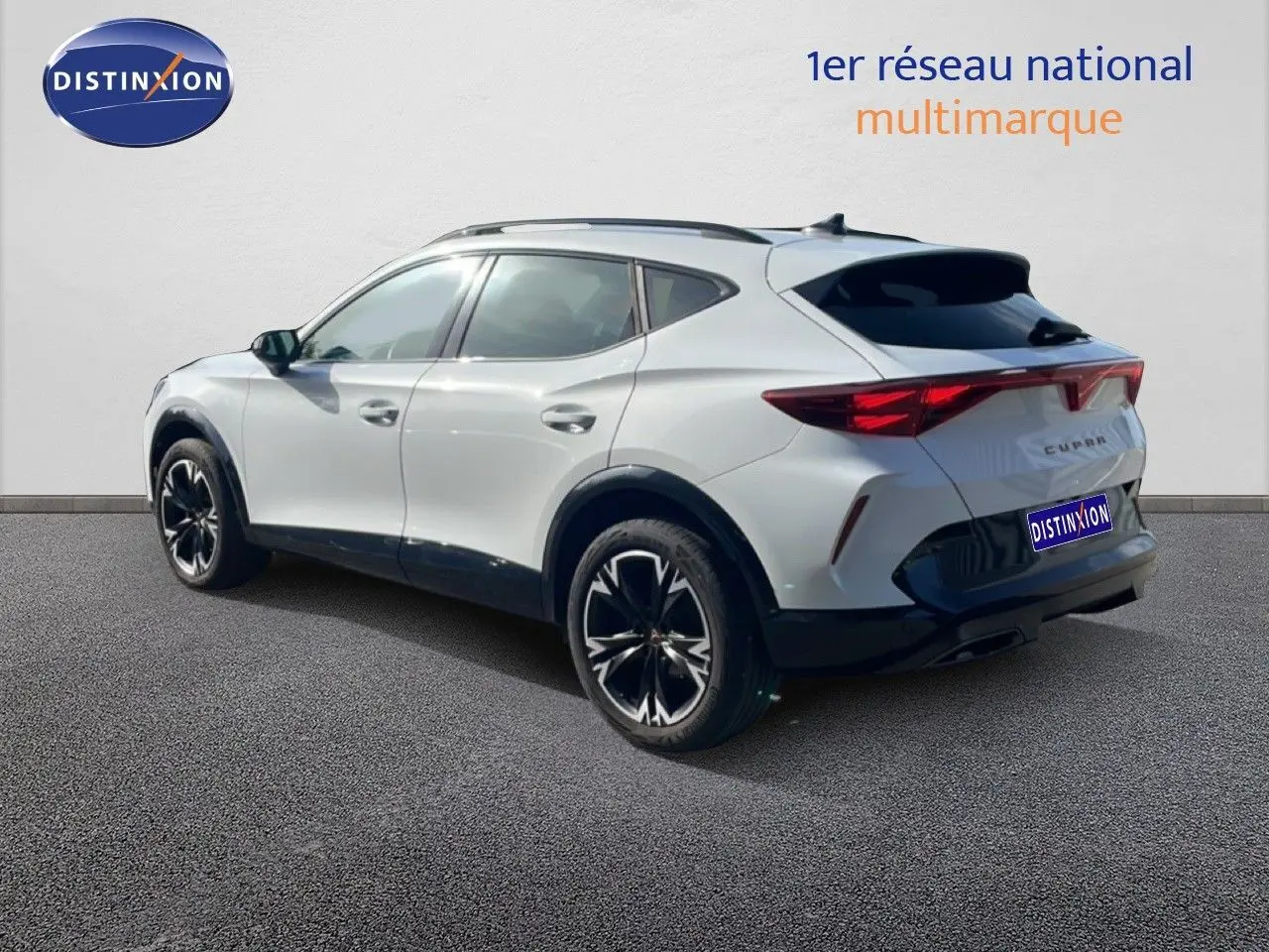 Vue 3/4 arrière droite d’un CUPRA Formentor blanc neige métal avec jantes noires et toit panoramique.